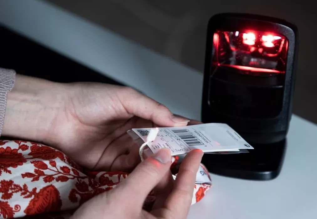 Close-up of hands scanning apparel barcode tag for inventory