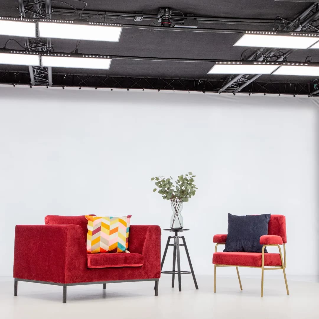 Modern red armchairs and side table in professional photo studio