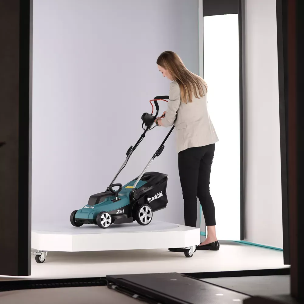 Woman operating Makita cordless lawn mower in a studio