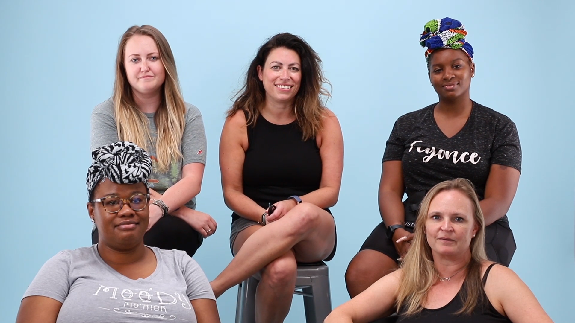 Group of Five Women Sitting Together on Blue Background