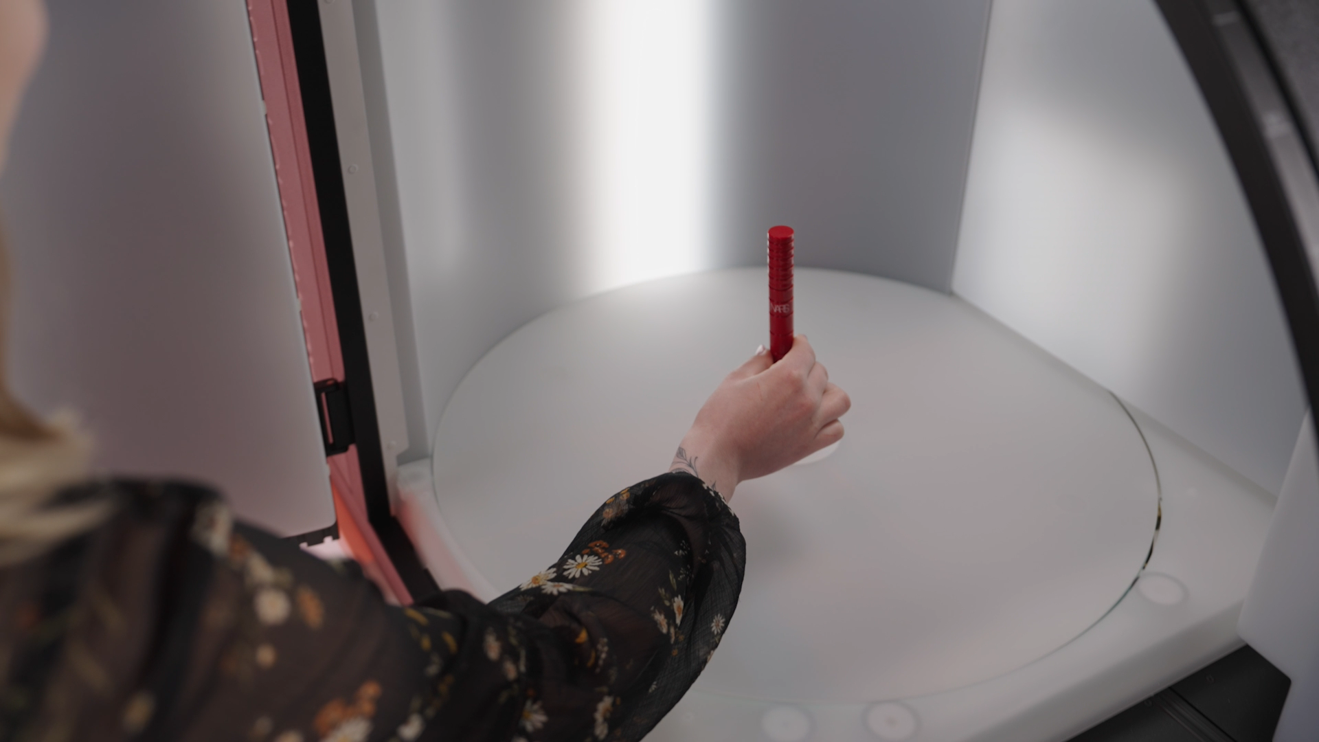 Hand Placing Red Product in Photo Studio Light Box