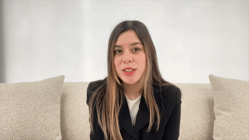 Woman in Black Blazer Speaking on a Beige Couch
