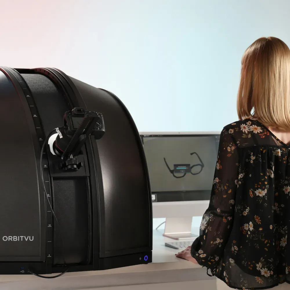 Frau bedient das automatisierte Orbitvu Brillenfotografie-System