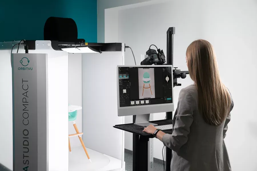 Product Photographer Post-Processing Baby High Chair Image on Computer