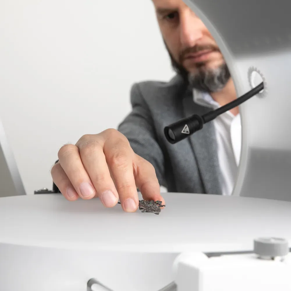 Man Positioning Small Product for Automated Studio Photography
