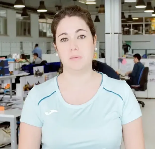 Woman in Light Blue Top Speaking in Busy Office Setting
