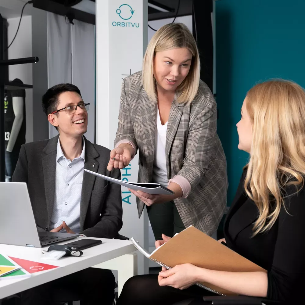 Business team discussion in office with Orbitvu branding