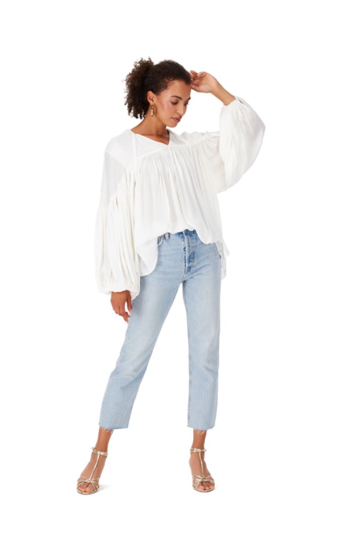 Woman in White Blouse with Volume Sleeves and Light Wash Jeans